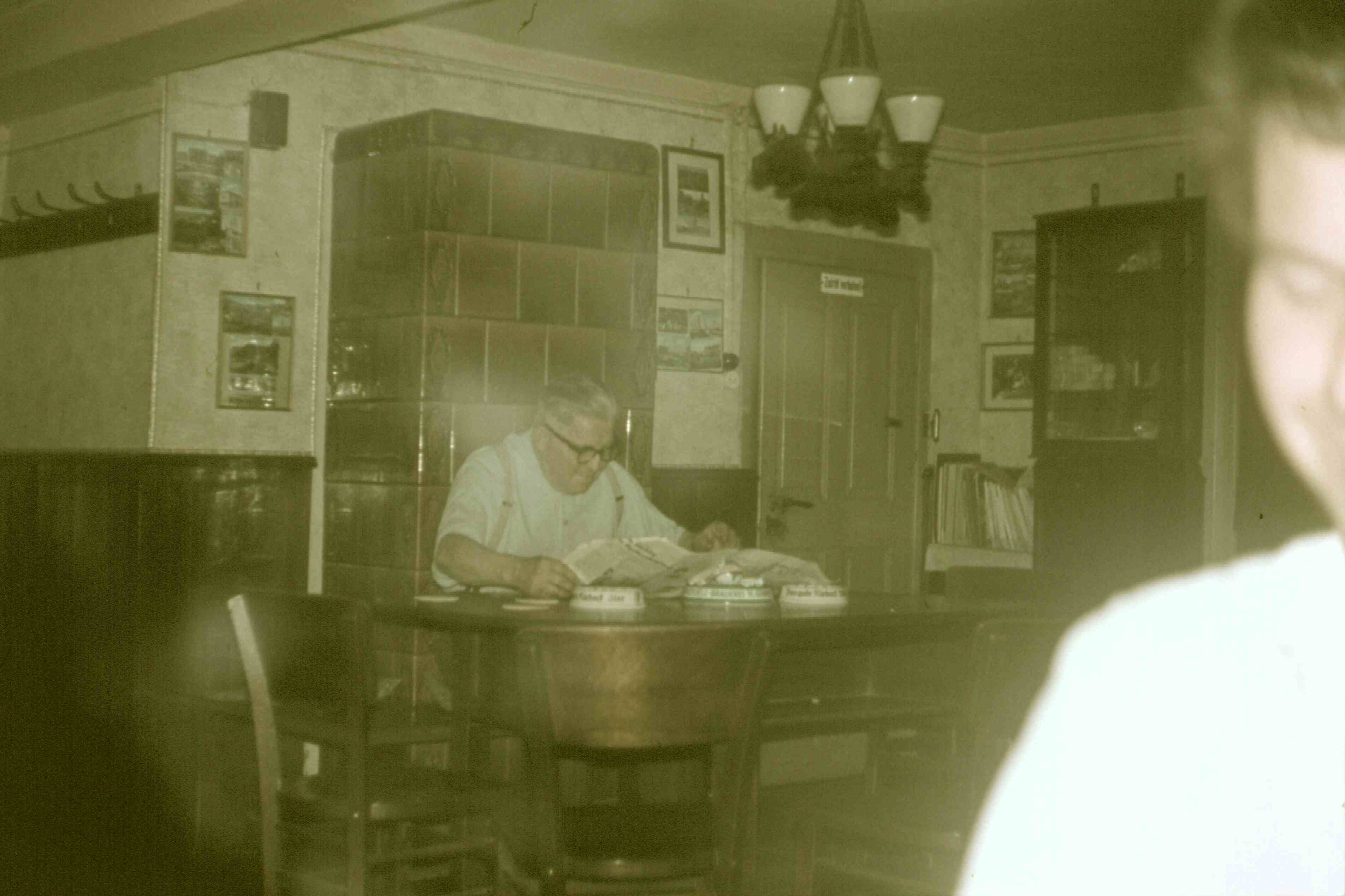 Gastwirt Kurt Ronniger vorm Kachelofen